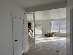 Hall with wood-type flooring and a textured ceiling