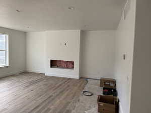 Unfurnished living room with light hardwood / wood-style floors and a textured ceiling