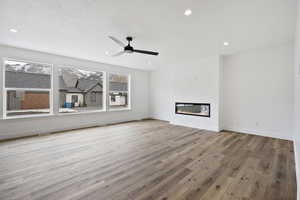 Unfurnished living room with ceiling fan and light hardwood / wood-style floors