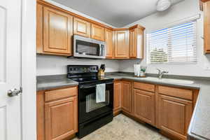 Kitchen with black range with electric cooktop and sink