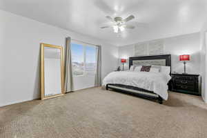 Carpeted bedroom featuring ceiling fan