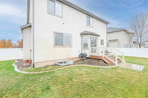 Back of house featuring a lawn and fence