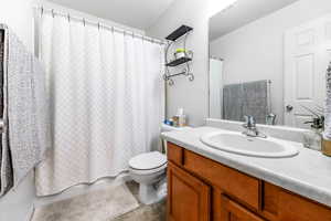 Bathroom featuring vanity, shower/tub combo and toilet.