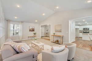 Living room featuring hardwood flooring and vaulted ceiling