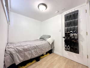 Bedroom featuring wood-type flooring and a textured ceiling