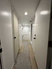 Hallway featuring stacked washing maching and dryer