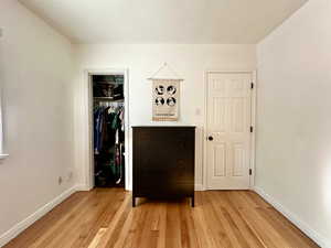 Unfurnished bedroom with light wood-type flooring and a closet