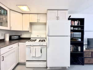 Kitchen featuring white cabinets and white appliances