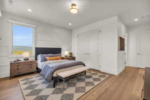 Bedroom with light hardwood / wood-style floors and a closet