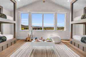 Bunkroom with lofted ceiling and light hardwood / wood-style flooring