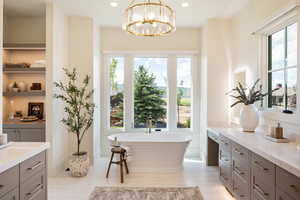 Master Bathroom with vanity, plenty of natural light, a bath, and an inviting chandelier