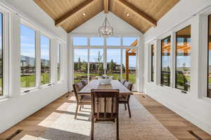 Sunroom featuring lofted ceiling with beams, wood ceiling, and a chandelier