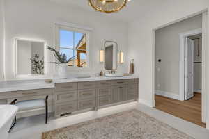 Master Bathroom featuring heated tile flooring, vanity, and beautiful decorative chandelier.