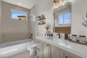 Full bathroom featuring tiled shower / bath, vanity, toilet, and tile patterned floors