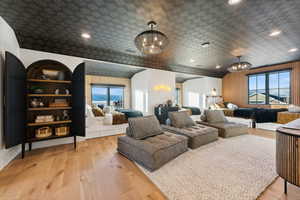 Bunkroom featuring an inviting chandelier, built in features, and light oak flooring