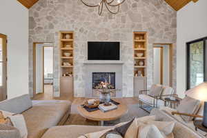 Living room featuring high vaulted ceiling, hardwood / wood-style flooring, a fireplace, and wooden ceiling