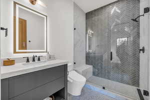 Ensuite Bathroom with vanity, toilet, and a shower with shower door