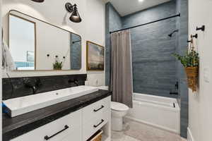 Full bathroom featuring vanity, toilet, and shower / tub combo