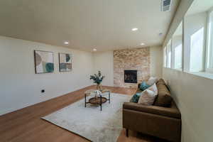 Living room with a fireplace and hardwood / wood-style flooring