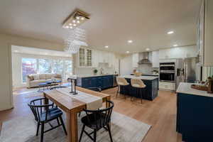 Dining space with a chandelier, sink, and light hardwood / wood-style flooring