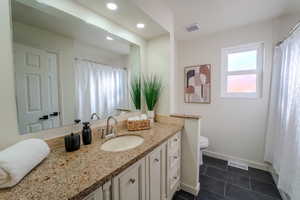 Bathroom with tile patterned flooring, vanity, and toilet