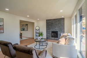 Living room featuring light wood-type flooring and a stone fireplace