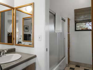 Bathroom with vanity and enclosed tub / shower combo