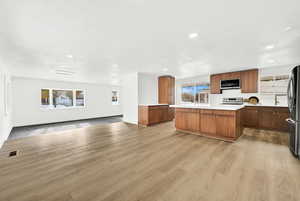 Kitchen with a center island, stainless steel appliances, and light hardwood / wood-style flooring