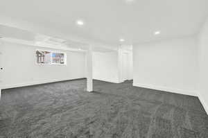 Basement family room with light gray colored carpet