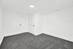 Basement bedroom with light gray colored carpet