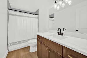 Bathroom with wood-style floors, vanity, and toilet