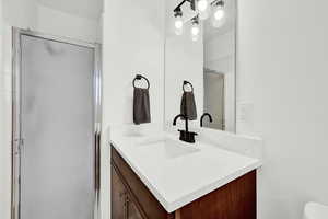 Bathroom featuring vanity and a shower with door