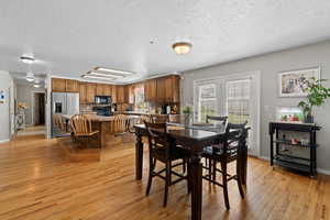 Dining area with a textured ceiling and light hardwood / wood-style flooring