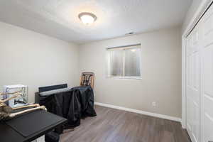 Office area with hardwood / wood-style floors and a textured ceiling