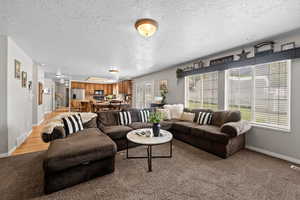 Living room with a textured ceiling and a wealth of natural light