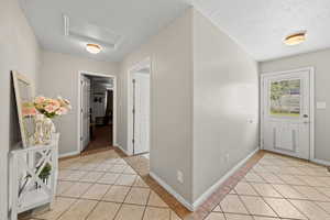 Tiled foyer with a textured ceiling