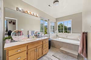 Master Bathroom with vanity, tile patterned floors, and tiled tub