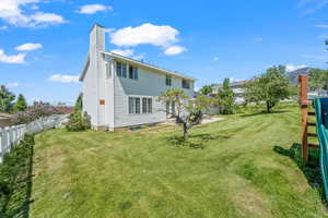 Rear view of house featuring a lawn