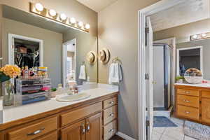 Master Bathroom with tile patterned flooring, vanity, and a shower with shower door