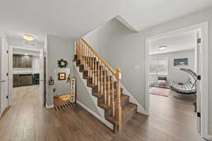 Staircase with wood-type flooring and a textured ceiling