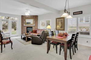 Dining room with a fireplace, and light colored carpet