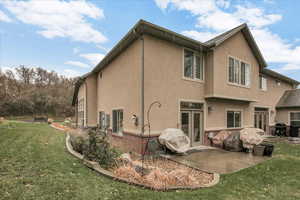 Rear view of property with a patio area and a yard