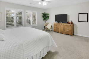 Carpeted bedroom with ceiling fan