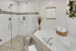 Bathroom featuring tile patterned flooring and shower with separate bathtub