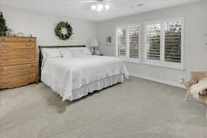 Carpeted bedroom with ceiling fan