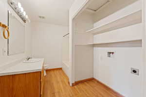 Full bathroom featuring shower / bath combination, vanity, wood-type flooring, and toilet