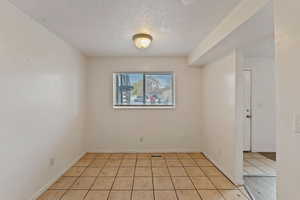 Tiled spare room with a textured ceiling