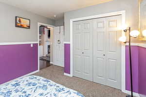 Carpeted bedroom featuring a closet