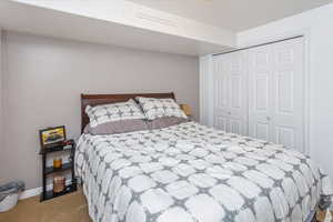 Bedroom featuring light carpet and a closet