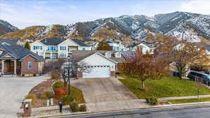 View of front of house featuring a mountain view, a garage, and a front yard